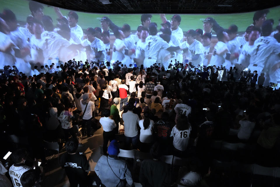 People celebrate Japan's victory against United States as they watch on a live stream of a World Baseball Classic (WBC) final being played at LoanDepot Park in Miami, during a public viewing event Wednesday, March 22, 2023, in Tokyo. (AP Photo/Eugene Hoshiko)