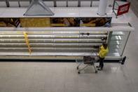 A woman takes a photo of empty shelves at Sainsbury's supermarket