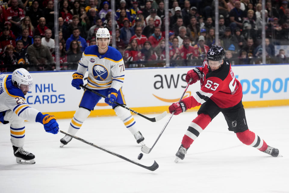 Buffalo Sabres' Mattias Samuelsson, left, trise to block a shot by New Jersey Devils' Jesper Bratt during the NHL hockey game between Buffalo Sabres and New Jersey Devils, in Prague, Czech Republic, Saturday, Oct. 5, 2024. (AP Photo/Petr David Josek)