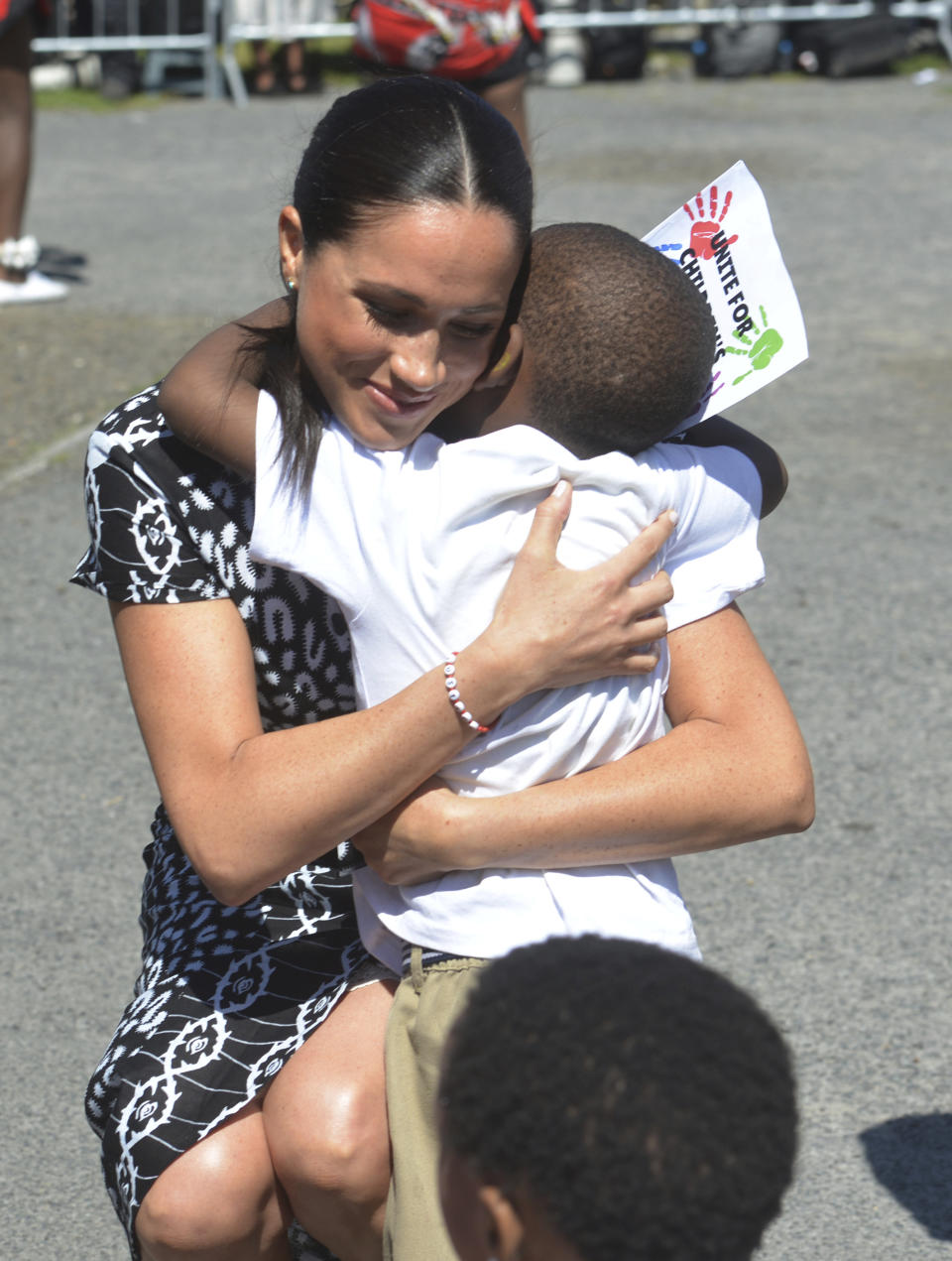 Britain's Meghan Duchess of Sussex, hugs a child on her arrival at the Nyanga Methodist Church in Cape Town, South Africa, Monday, Sept, 23, 2019, which houses a project where children are taught about their rights, self-awareness and safety, and are provided self-defence classes and female empowerment training to young girls in the community. The royal couple Harry and Meghan are starting their first official tour as a family with their infant son, Archie. (Courtney Africa / Africa News Agency via AP, Pool)