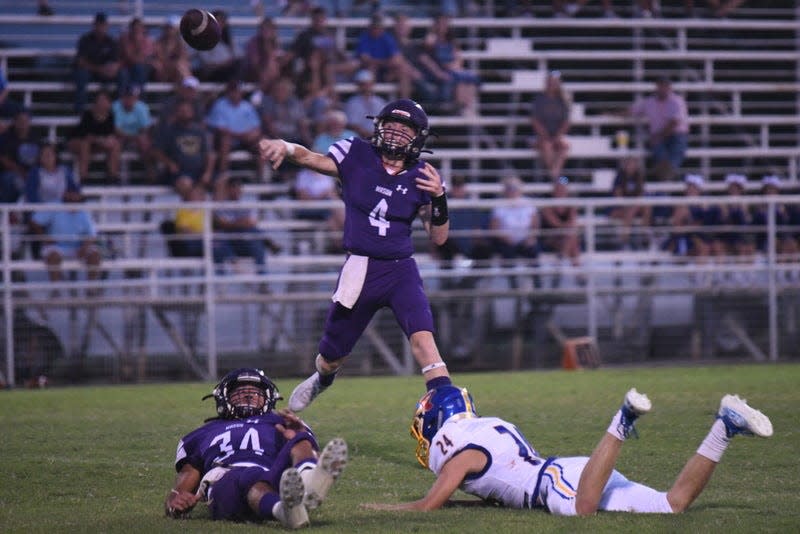 Mason High School's Ivan Wofford gets rid of the ball as Jaden Scantlin (34) holds off a Comfort pass rusher during a nondistrict high school football game Friday, Sept. 3, 2021, at R. Clinton Schulze Stadium in Mason.