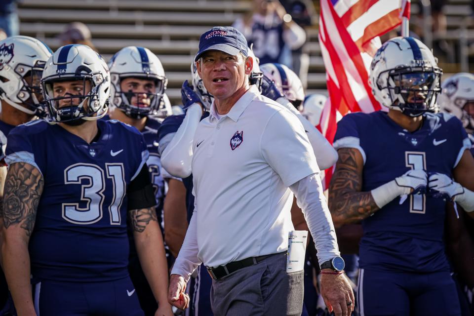 Connecticut coach Jim Mora walks the sideline before his team's game against Liberty at Rentschler Field at Pratt & Whitney Stadium.