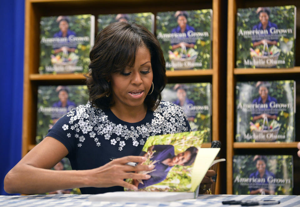 US First Lady Michelle Obama signs a copy of her book 'American Grown: The Story of the White House Kitchen Garden and Gardens Across America,' during a book signing event at Politics & Prose in Washington, DC, on May 7, 2013. Photo credit:  JEWEL SAMAD/AFP/Getty Images