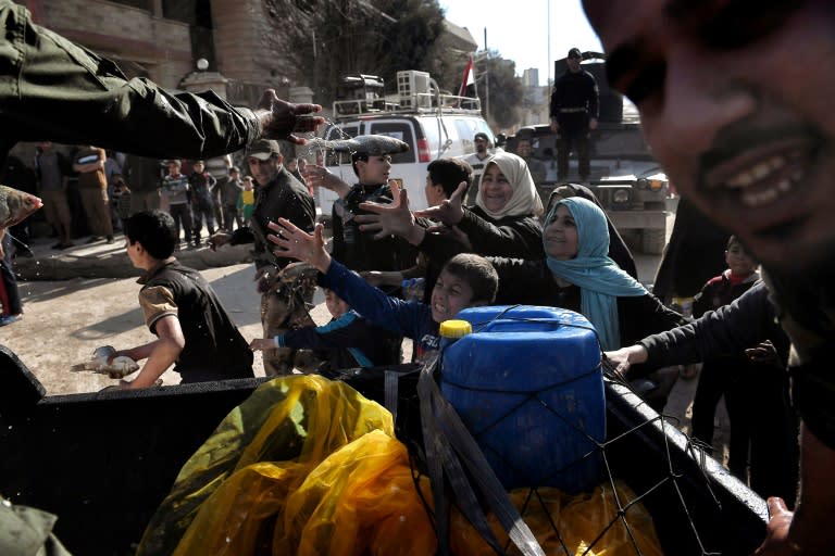 Iraqi troops distribute food aid to residents of west Mosul on March 10, 2017 as Iraqi forces advance in the city