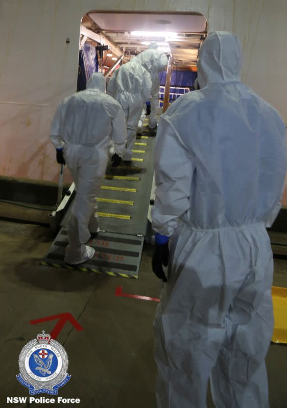 Personnel in protective gear are seen boarding the Ruby Princess during the NSW Police Strike Force Bast raid of the cruise ship at Port Kembla