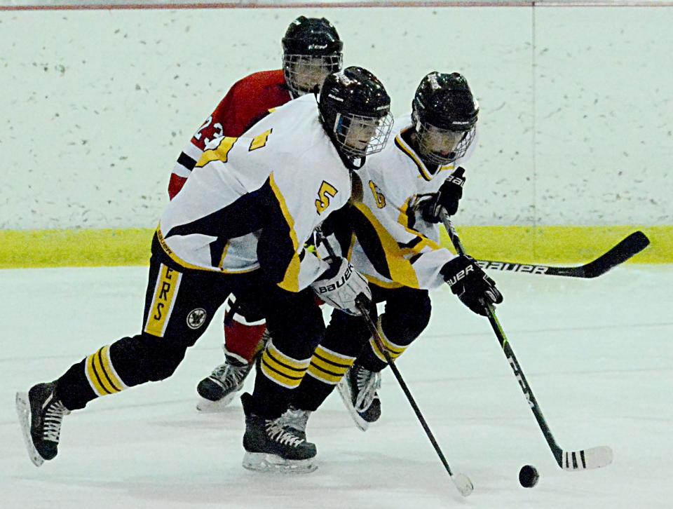 Cate Holien (5) and Kayla Randall (16) of the Watertown Lakers grab control of the puck in front of Huron's Jolie Carrillo during their South Dakota Amateur Hockey Association varsity girls game Friday night in the Maas Ice Arena.
