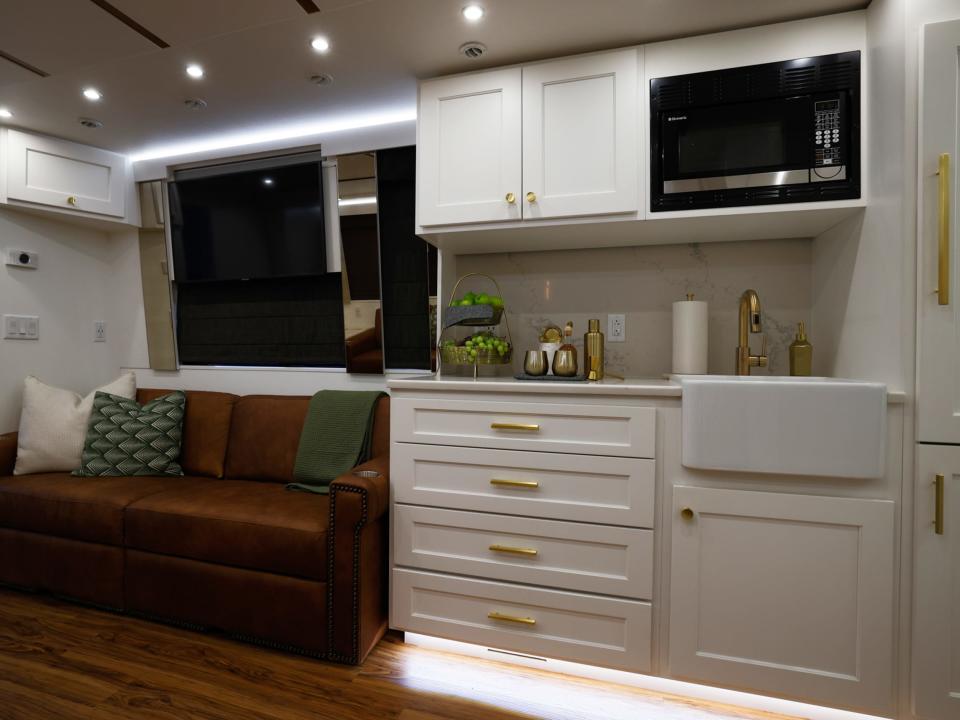 a kitchen and living room inside an artist bus with Dreamliner Luxury Coaches