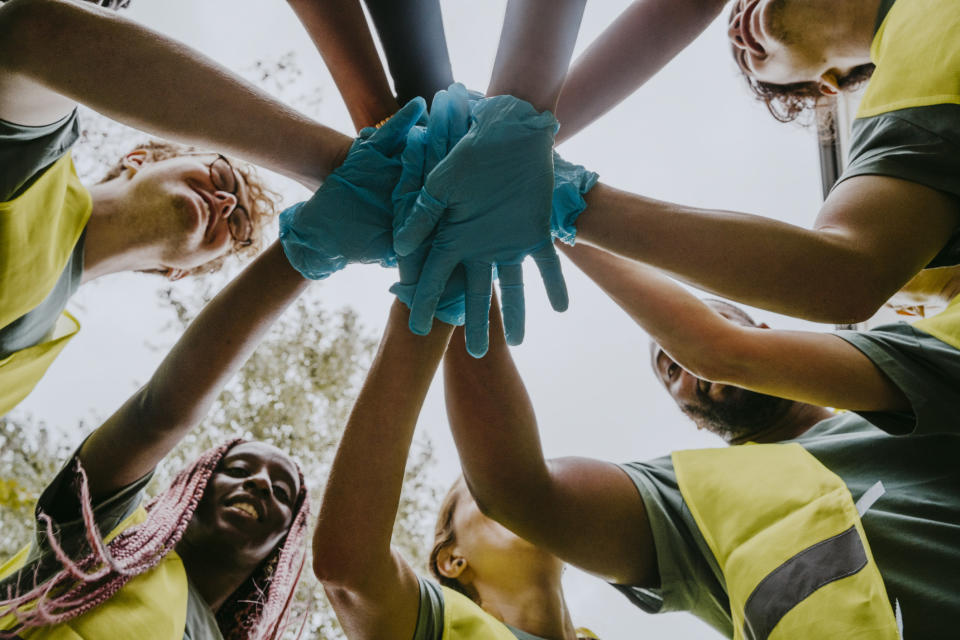 People in yellow vests putting their hands together