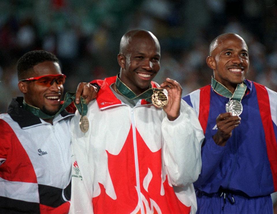 FILE - In this July 27, 1996, file photo, Bronze medalist Ato Boldon of Trinidad and Tobago, left, gold medalist Donovan Bailey of Canada, center, and silver medalist Frankie Fredericks of Namibia pose with their medals after the men's 100 meter final at the 1996 Summer Olympics in Atlanta. (AP Photo/David Longstreath, File)