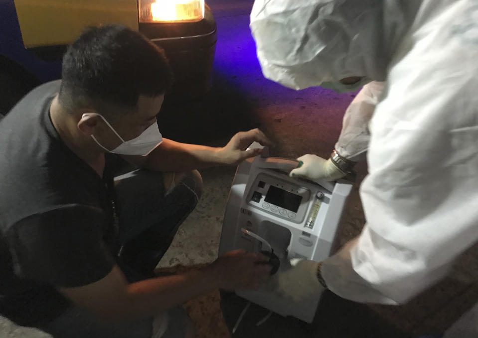 Volunteers from the "Saimai Will Survive" group prepare an oxygen generator for victims with COVID-19 outside their home Friday, July 23, 2021, in Bangkok, Thailand. As Thailand's medical system struggles beneath a surge of coronavirus cases, ordinary people are helping to plug the gaps, risking their own health to bring care and supplies to often terrified, exhausted patients who've fallen through the cracks. (AP Photo/Tassanee Vejpongsa)