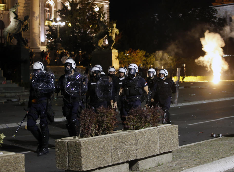 Serbian police officers guard the parliament building in Belgrade, Serbia, Tuesday, July 7, 2020. Thousands of people protested the Serbian president's announcement that a lockdown will be reintroduced after the Balkan country reported its highest single-day death toll from the coronavirus Tuesday. (AP Photo/Darko Vojinovic)