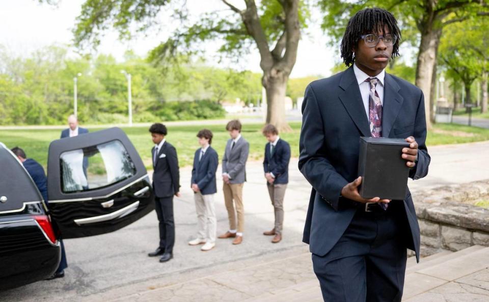 Dominion Yarbrough carries a cremated body to its final resting place during a May 4 funeral service for unclaimed deceased persons at the Mount Olivet Catholic Cemetery in Raytown.