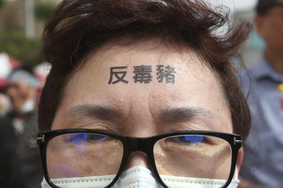 A participant has a slogan "Anti-poisoned pork" written on her forehead during a protest in Taipei, Taiwan, Sunday, Nov. 22. 2020. Thousands of people marched in streets on Sunday demanding the reversal of a decision to allow U.S. pork imports into Taiwan, alleging food safety issues. (AP Photo/Chiang Ying-ying)