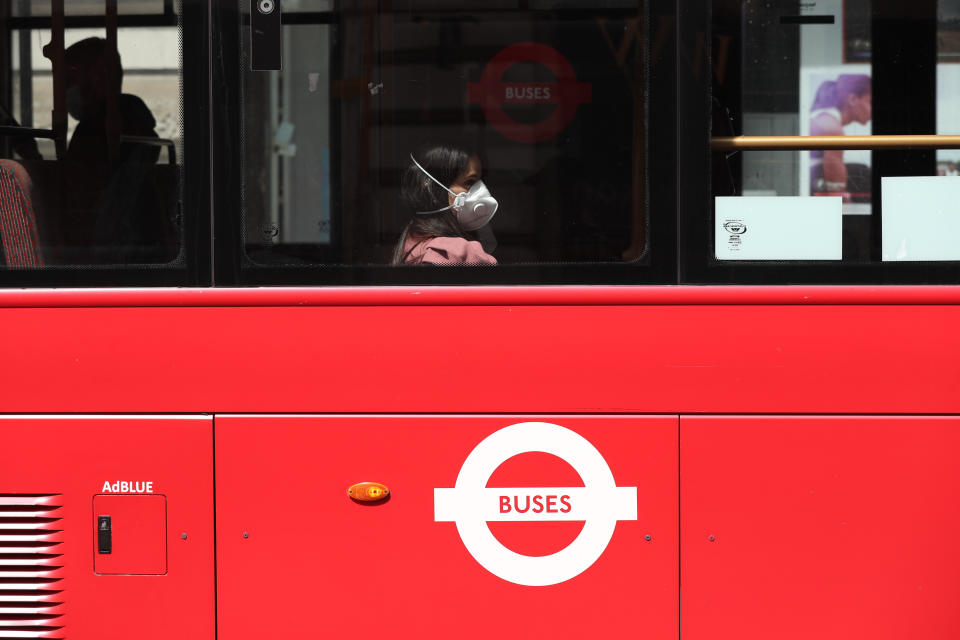 A person wearing a face mask rides a bus on Piccadilly, London, following the introduction of measures to bring England out of lockdown. (Photo by Jonathan Brady/PA Images via Getty Images)