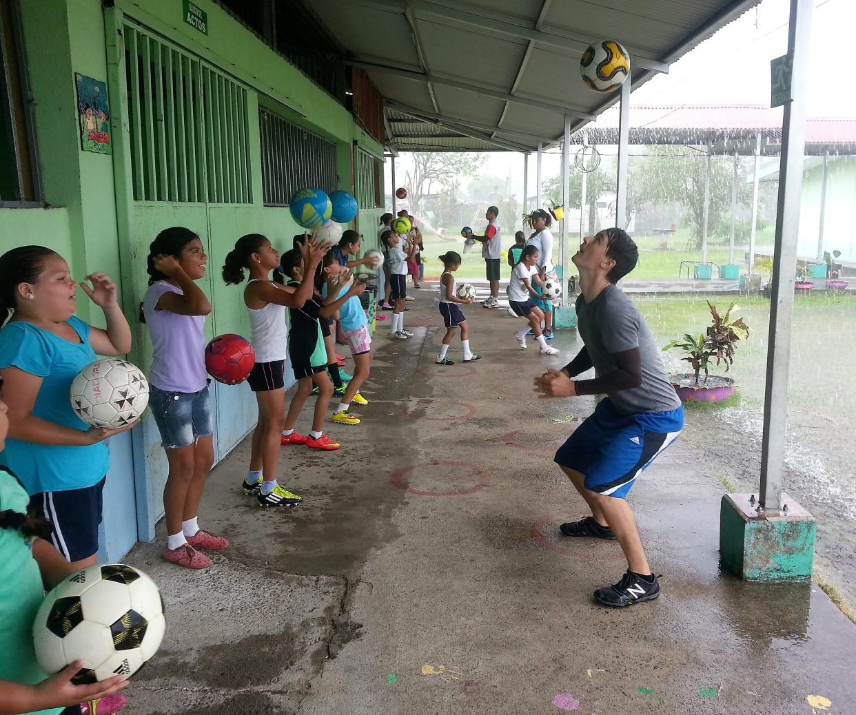 In Costa Rica a Peace Corps volunteer moves soccer practice under a covered area during a rainstorm.