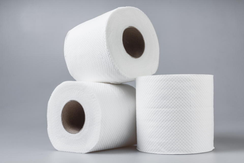 Three rolls of toilet paper stacked, with the top roll on its side