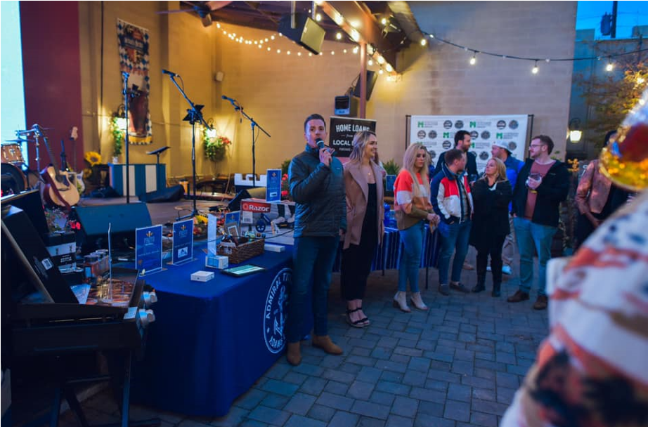 Pints for Purpose board chair Tom Burnette and vice chair Madi Archer present the raffle items at their November event at Schulz Brau benefiting Care Cuts of Knoxville.