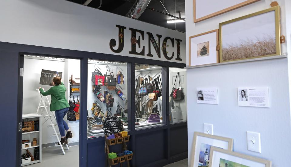 Jennifer Couch, owner of JENCI, plans out how she wants to hang photos in her 130-square-foot retail space at Market on Main.
