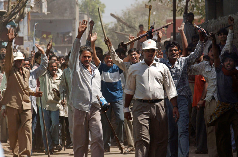 401733 09: A mob of Hindus wielding swords and sticks back off after Indian Rapid Reaction Force officers stopped them from attacking a small group of Muslims March 1, 2002 in Ahmadabad, India.<span class="copyright">Ami Vitale—Getty Images</span>