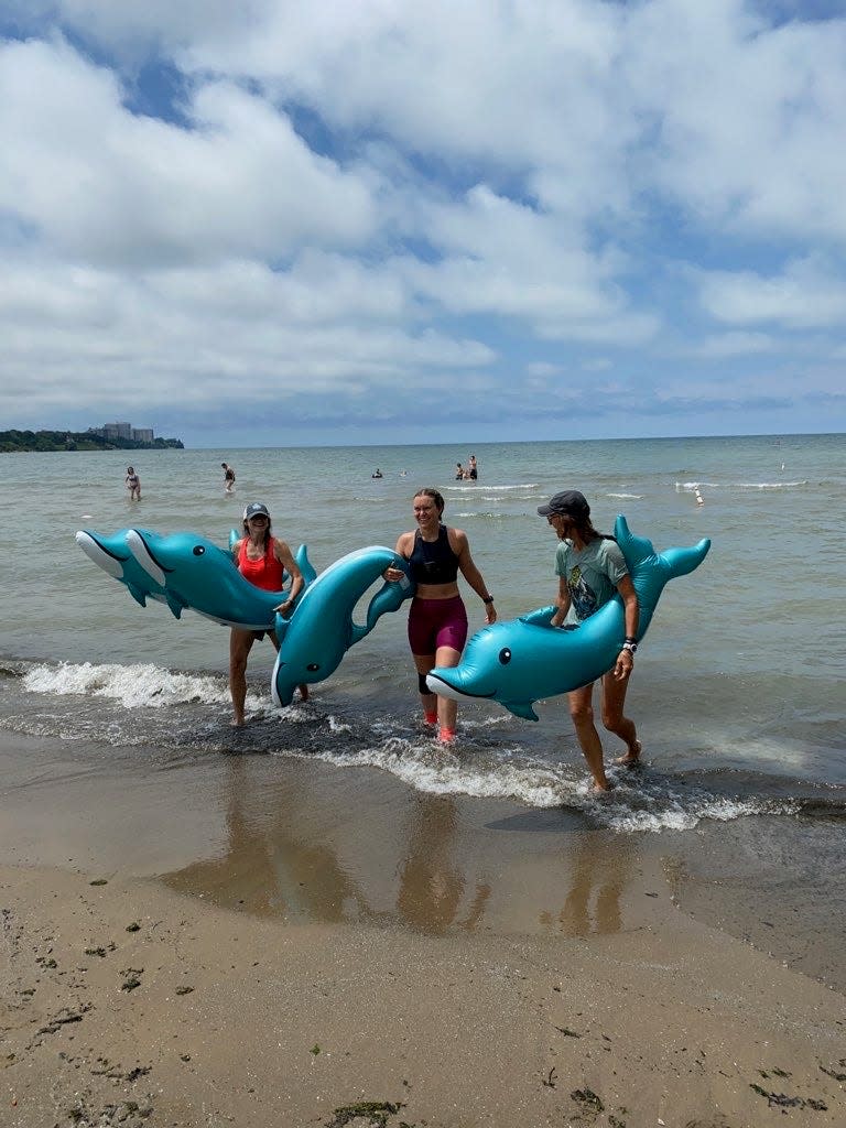 Spotz and her crew members exiting Lake Erie with blow-up pool dolphins after she completed her Run4Water across Ohio on July 1.