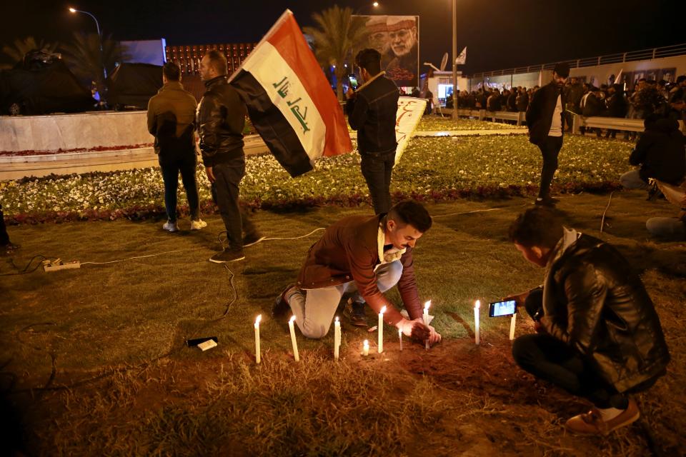 Popular Mobilization Forces and their supporters light candles at Baghdad's international airport on Saturday, Jan. 2, 2021, on the anniversary of the killing of Abu Mahdi al-Muhandis, deputy commander of the PMF and Gen. Qassem Soleimani, head of Iran's Quds forces in a U.S. airstrike. (AP Photo/Khalid Mohammed)