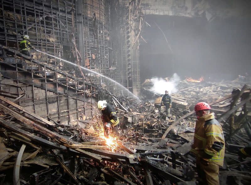 Miembros del Ministerio de Emergencias ruso trabajan entre los escombros de la sala de conciertos Crocus City Hall, a las afueras de Moscú, Rusia.