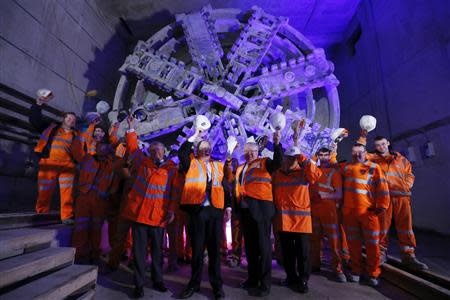 London Mayor Boris Johnson raises his hard hat as he poses with workers, the Secretary of State for Transport Patrick McLoughlin (R) and Andrew Wolstenholme the CEO of Crossrail (L) at the official announcement that tunnelling machine Elizabeth has broken into the Crossrail station at Canary Wharf, in east London, May 31, 2013. REUTERS/Andrew Winning