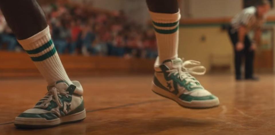 Lucas's wearing green and white Converse on the basketball court