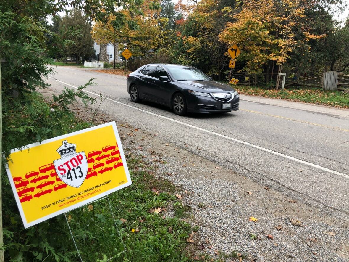 Opponents of the proposed GTA West Highway display a lawn sign in Belfountain, part of the town of Caledon, Ont. The proposed 50-kilometre-long route of Highway 413 would connect Vaughan to Milton by cutting through Caledon.    (Mike Crawley/CBC - image credit)