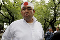In this Aug. 15, 2019, photo, Hirotomi Igarashi, a construction company owner who heads a right-wing group, speaks to reporters at Yasukuni Shrine. Some of Japan’s views on history could be seen recently when throngs of people flocked to Tokyo’s Yasukuni Shrine recently to pay respect to war dead, some carrying the rising-sun flag and banners that said, “Banzai to the emperor.”(AP Photo/Yuri Kageyama)
