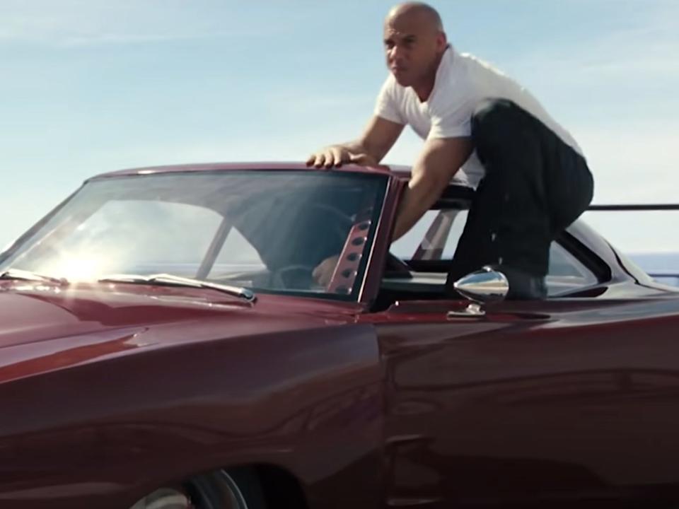 Vin Diesel jumping out of a red car in "Fast and Furious 6."