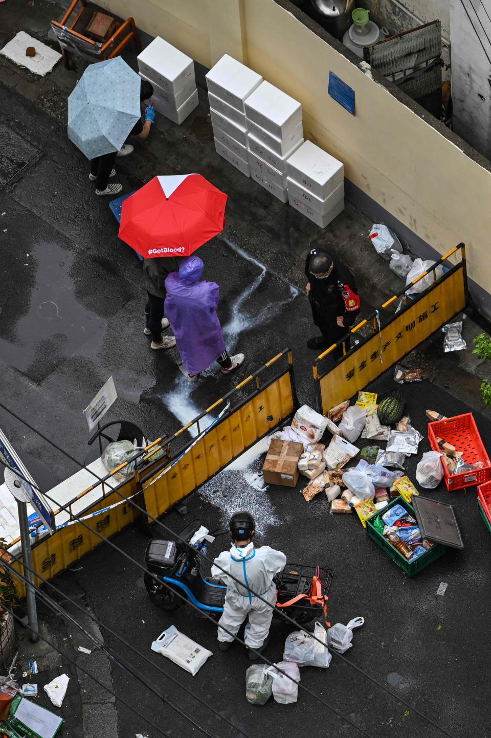 People are seen next to a checkpoint on a street during a COVID-19 lockdown in the Jing'an district in Shanghai on April 23, 2022.