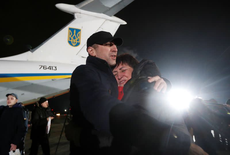 A Ukrainian citizen exchanged during a prisoners of war swap embraces a relative at an airport outside Kiev