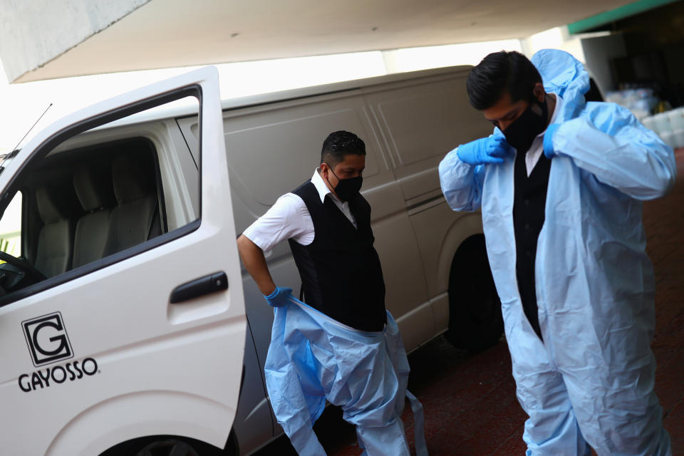 Employees of Funeral Gayosso wear protective clothing before transporting a deceased person, as the outbreak of the coronavirus disease (COVID-19) continues in Mexico City, Mexico May 11, 2020. Picture taken May 11, 2020. REUTERS/Edgard Garrido