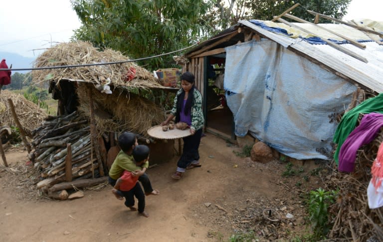 Nepalese migrant worker Sunita Magar (C), who was trafficked to Syria, seen with her children in front of their house in Dhadhing district, some 100 km west of Kathmandu