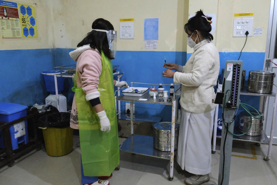 Shimray Wungreichon, 43, right, prepares to administer a shot to a patient at the District Hospital where she is the single nurse on overnight duty at the emergency ward, in Ukhrul, in the northeastern Indian state of Manipur, Friday, Jan. 15, 2021. Wungreichon was among the first of many Indian health workers to be vaccinated on Saturday, opening a new chapter in the battle against the pandemic in the world's second hardest-hit country, which has been scarred profoundly by a virus that has killed more than 152,000 of its people. (AP Photo/Yirmiyan Arthur)