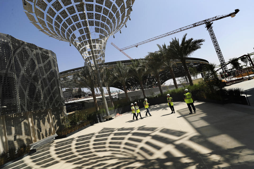 In this Oct. 8, 2019, photo, Associated Press journalists visit the Sustainability Pavilion at the under construction site of the Expo 2020 in Dubai, United Arab Emirates. Its Sustainability Pavilion, which recalls the towers of New York’s 1964 world’s fair, will be covered in solar panels and surrounded by similarly paneled “energy trees” to make it a zero-energy structure. (AP Photo/Kamran Jebreili)