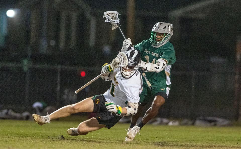 Pensacola Catholic's Andrew Frosch (11) and Trinity Catholic's Sean Thornton battle for the ball during the Pensacola Catholic vs Trinity Catholic Boys Lacrosse Region 1-1A quarterfinal Saturday, April 22, 2023 at Catholic High School.  Pensacola Catholic beat Trinity Catholic 12-8.