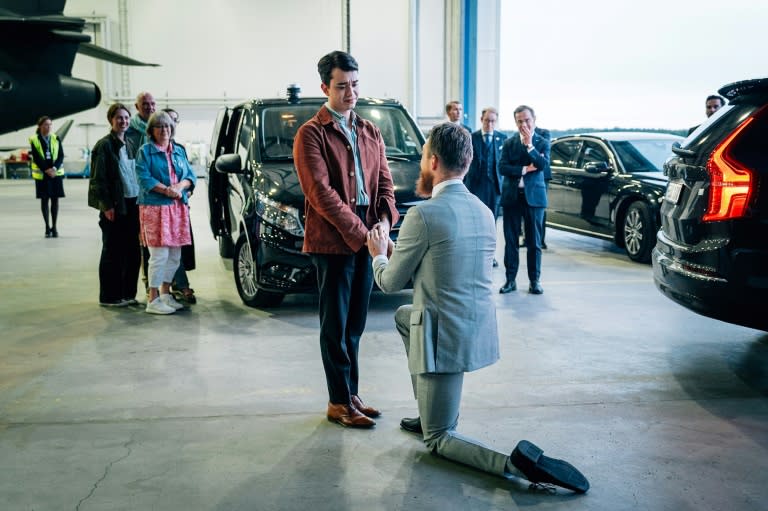 Johan Floderus, right, proposes to his partner surrounded by family upon arriving in Sweden on Saturday (Tom SAMUELSSON)