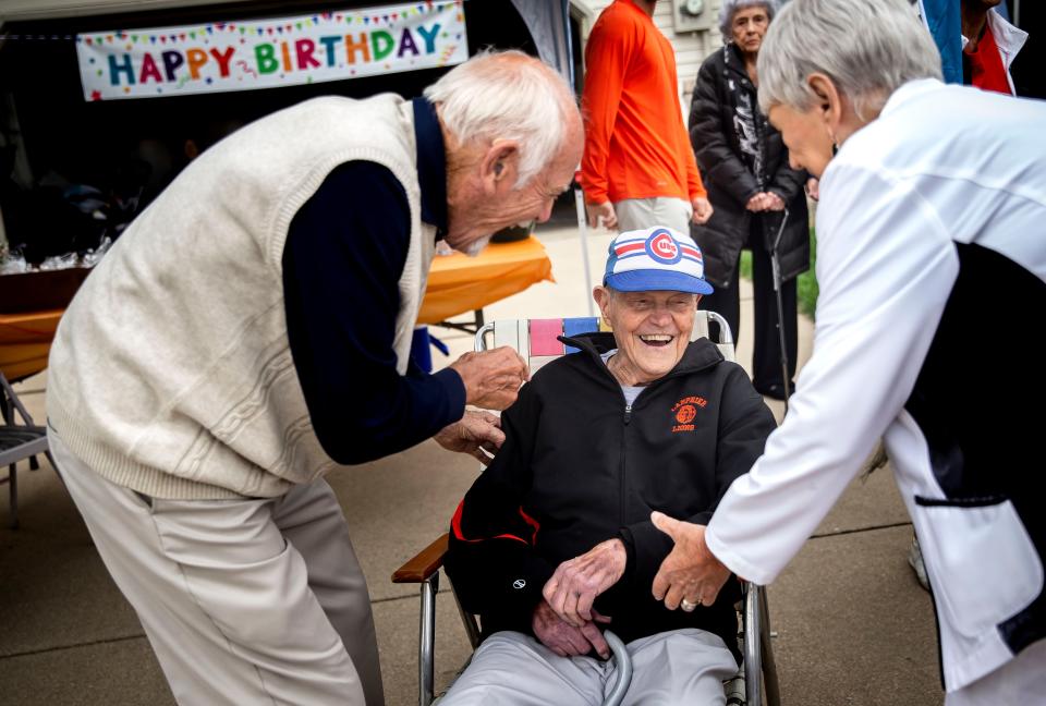 Arlyn Lober reminisces with lifelong friends Art and Jean Spiegel as family and friends gather for a driveway birthday party to celebrate Lober's 97th birthday in Springfield, Ill., Saturday, May 8, 2021. Lober, a World War II veteran that fought in the Battle of the Bulge, was a teacher at Lanphier High School for 33 years and for 22 of those years was a successful basketball coach for the Lions that took five teams to the state tournament. [Justin L. Fowler/The State Journal-Register]