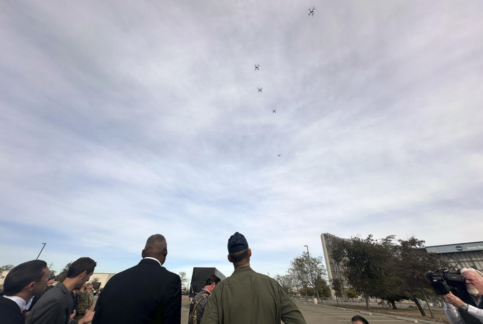 Defense Secretary Lloyd Austin watches as a swarm of five drones takes off from a parking area at the Defense Innovation Unit in Mountain View, Calif, on Friday, Dec. 1, 2023. Austin was able to see a number of projects being developed at DIU, including a virtual training device that will help Ukrainian pilots learn to fly F-16 fighter jets and swarming drones being developed for warfighters. (AP Photo/Lolita Baldor)