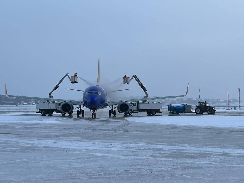 Two deicer technicians apply Type I aircraft deicer to a plane while a recovery tractor collects overspray in a tank. Type I deicer is applied hot and is used to remove ice and snow that is already present on the plane. A recent study shows that airplane deicers are polluting waterways near Milwaukee Mitchell International Airport with phosphorus.