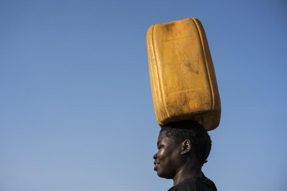 In this photo taken Wednesday, March 8, 2017, a young girl carries clean water home from a water treatment point built by UNICEF in Torit, South Sudan. As World Water Day approaches on March 22, more than 5 million people in South Sudan, do not have access to safe, clean water, compounding the problems of famine and civil war, according to the UNICEF. (Mackenzie Knowles-Coursin/UNICEF via AP)