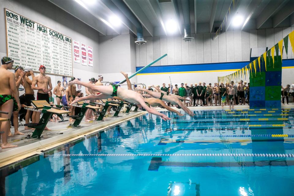 Iowa City High and West High swimmers leap off the blocks during a Class 4A swimming meet on Tuesday, Jan. 15, 2019, at the Coralville Recreation Center, in Coralville, Iowa.