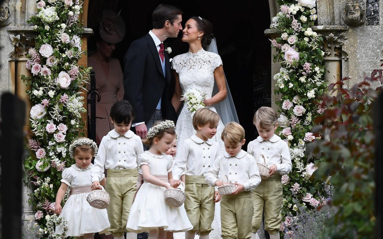 Pippa Middleton kisses her new husband James Matthews, following their wedding ceremony as the bridesmaids and pageboys walk ahead - Getty Images Europe