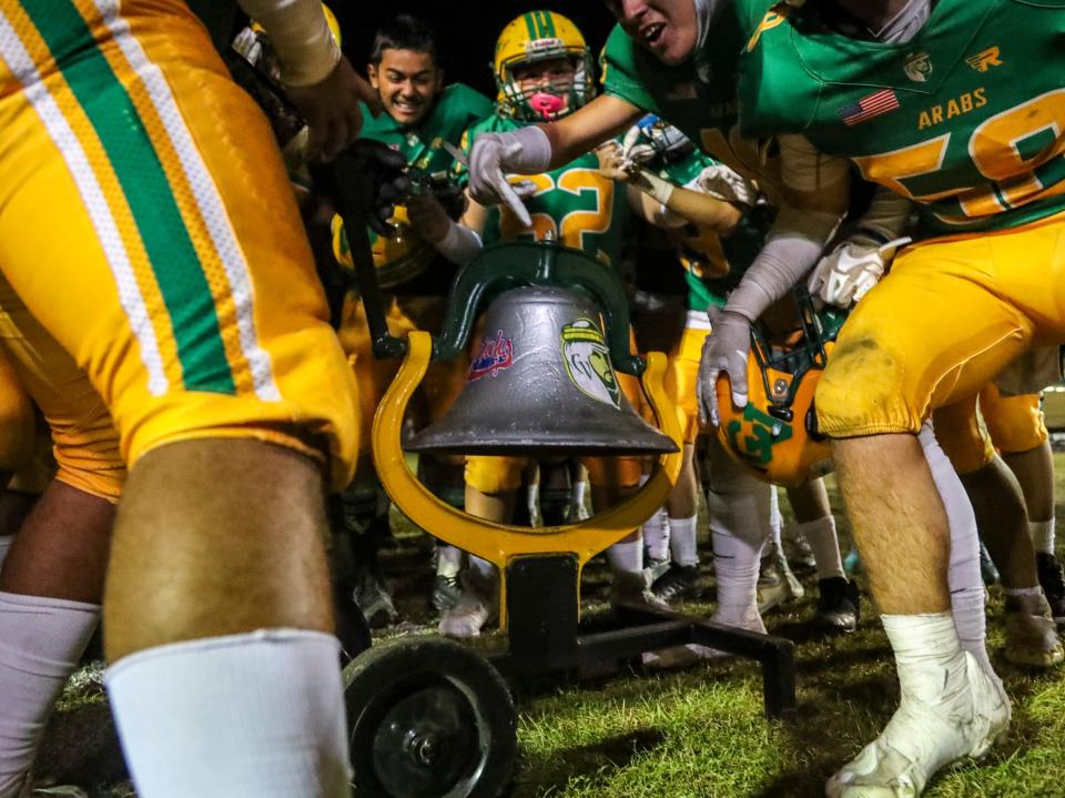 Coachella Valley players huddle around the bell in celebration after winning the 63rd annual Bell Game at Coachella Valley High School in Thermal, Calif., Friday, Oct. 28, 2022. 