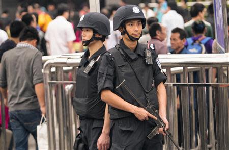 Armed policemen stand guard at a railway station after a knife attack in Guangzhou, Guangdong province May 6, 2014. REUTERS/Alex Lee