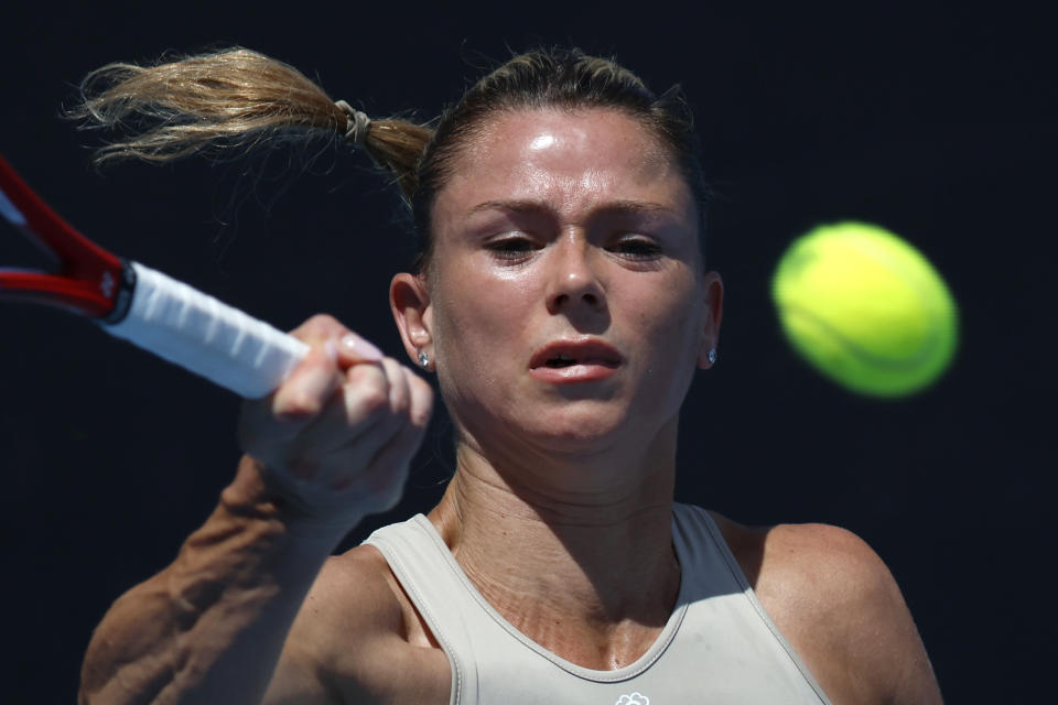 Camila Giorgi of Italy plays a forehand return to Anastasia Pavlyuchenkova of Russia during their first round match at the Australian Open tennis championship in Melbourne, Australia, Tuesday, Jan. 17, 2023. (AP Photo/Asanka Brendon Ratnayake)