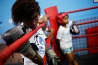 A girl looks at other children practicing on a boxing ring during an exercise session at a boxing school, in the Mare favela of Rio de Janeiro, Brazil, June 2, 2016. REUTERS/Nacho Doce