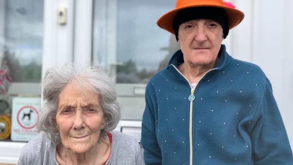 Close-up image of Patricia and Tina Hobby standing in front of their house